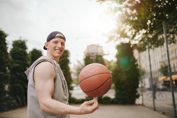 Smiling streetball player spinning the ball