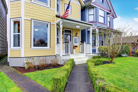 Exterior Of Yellow Family House With American Flag