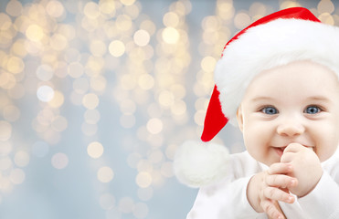 happy baby in santa hat over holidays lights