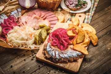 herring and snack on wooden background