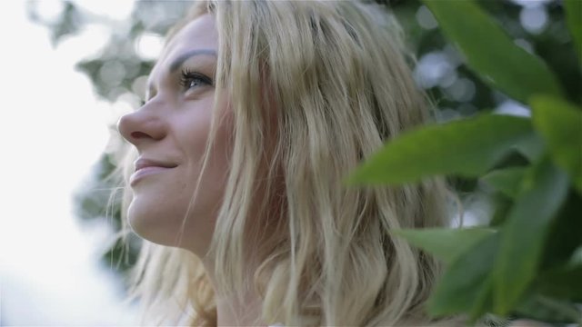A young girl's face surrounded by leaves.