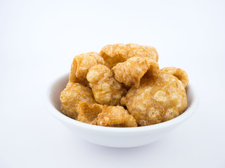 Crispy deep fried pork skin or pork rind in bowl isolated on white background