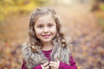 Adorable little girl in a autumn forest