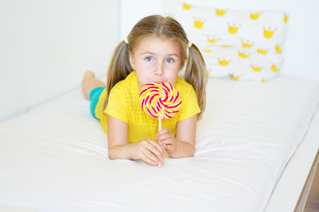 Funny little girl eating big sugar lollipop