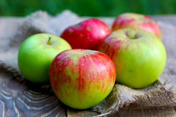 Ripe natural organic apples on wooden and coarse cloth sacking background