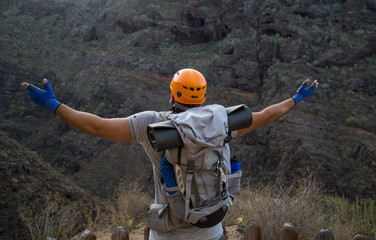 Backpacker man hiking and rising hands up in beautiful landscapes of Barranco del Infierno in Tenerife. Canary islands, Spain