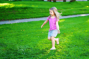Naklejka na ściany i meble Adorable little girl running on the meadow