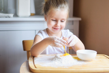 Obraz na płótnie Canvas Adorable little girl making the dough for pasta