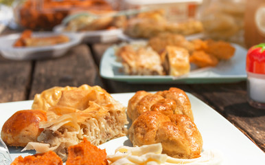 wooden picnic table with full of turkish pastry and a salt shaker in frame