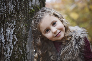 Adorable little girl in a autumn forest