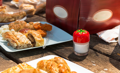 wooden picnic table with full of turkish pastry and a salt shaker in frame