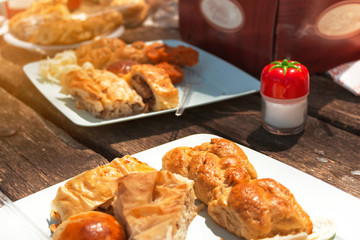wooden picnic table with full of turkish pastry and a salt shaker in frame