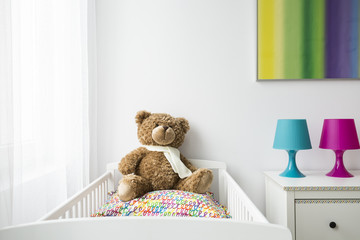 Child room with a cradle and teddy bear