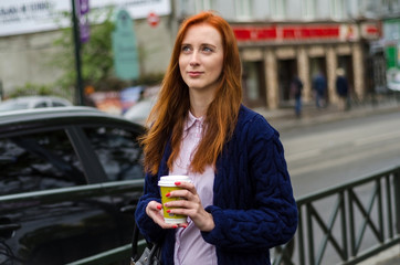 Young red woman with hot coffee