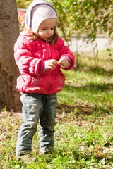 happy little child, baby girl playing in the autumn on the nature walk outdoors