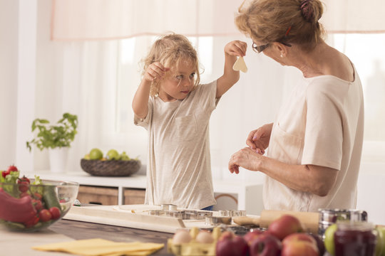 Kid showing cookies to nanny