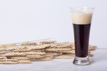 Black beer in the glass on the table