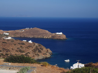 church monastery on promontory in Aegean Sea with houses and boa