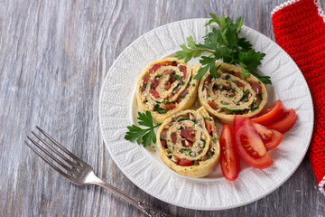 Vegetable roll with tomatoes, garlic and cheese on a wooden table, top view