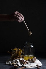 Honey dripping from a spoon in a jar