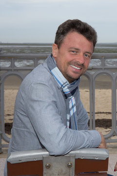 Man at the beach with scarf looking at the camera