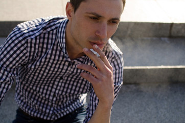 Obraz premium Young man smoking cigarette 