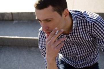Obraz premium Young man smoking cigarette 