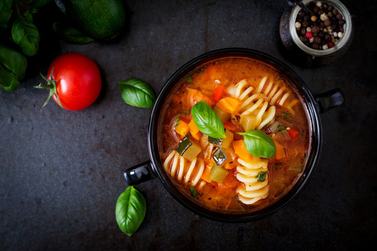 Minestrone, italian vegetable soup with pasta on black backgrounds. Top view