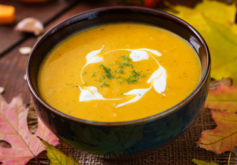 Cream of pumpkin soup with sour cream sauce. Halloween.