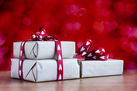 Christmas gifts boxes rustic packaging and heart shape bow on abstract background. Copy space