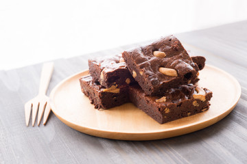 Chocolate brownie with cashew nuts on wooden background.