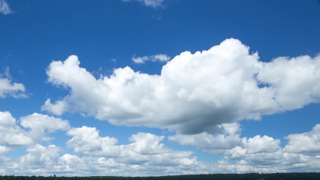 Time lapse video of white fluffy cumulus clouds against blue sky