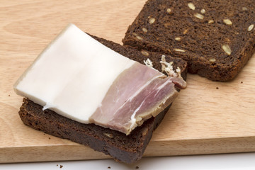Piece of salty bacon on rye bread