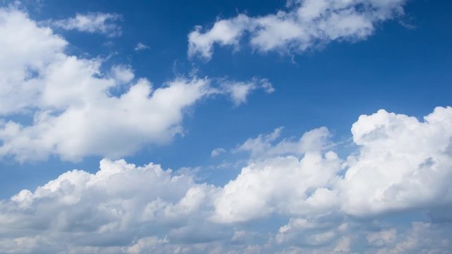 Time lapse video of white fluffy cumulus clouds against blue sky