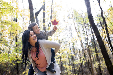 Adorable little boy with his mother in autumn park