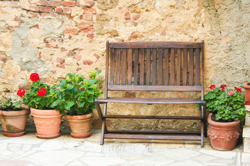 wooden bench and pottery against a stone wall, Tuscany, Italy 
