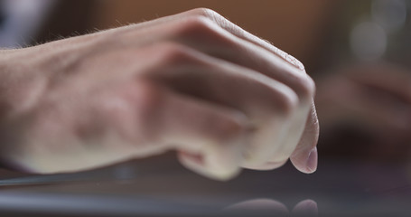 young man hand using tablet pc on table in cafe or home very shallow focus