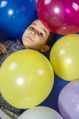 Fototapeta na wymiar child playing with colored balloons at a birthday party happy