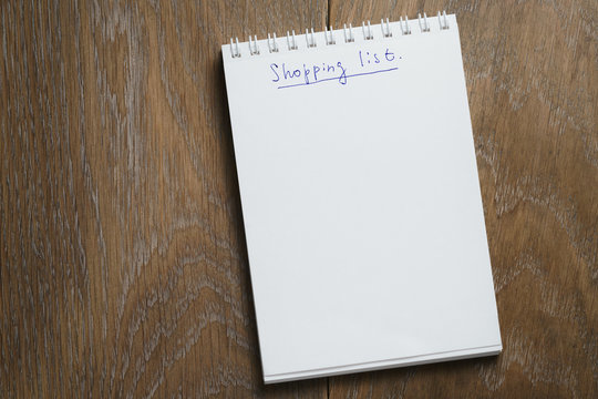 shopping list on notepad on wood table