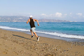 Fototapeta na wymiar Man runner sprinting on wet sand run at the beach