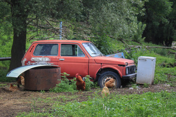 Old Soviet red vintage car Niva broken in the junk yard 