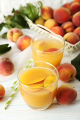 Glasses of peach juice on white wooden table