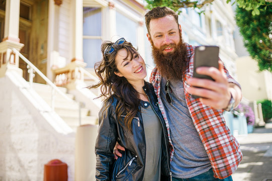 happy couple taking selfie at the painted ladies in san francisco