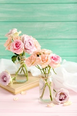 Bouquet of beautiful roses on a pink wooden table
