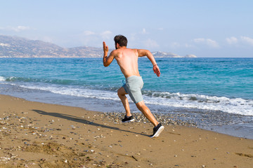 Fototapeta na wymiar Man runner sprinting on wet sand run at the beach