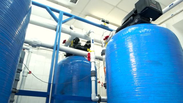 Industrial water filters. White pipes and red valves. Purification of water at plant. Newest equipment guarantees safety.