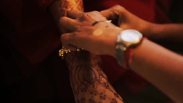 Woman puts luxuriant bracelet on bride's hand