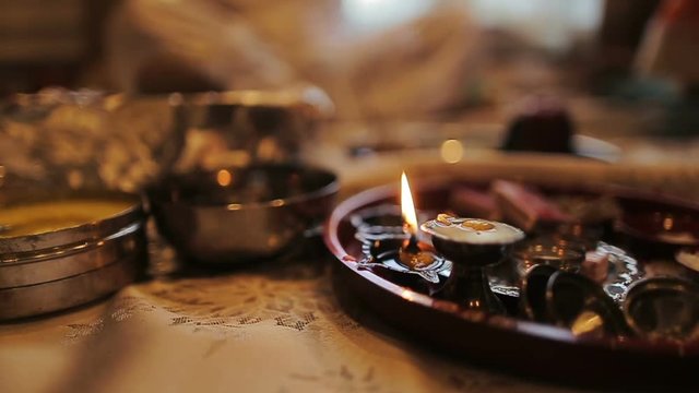 Little candle burns on the plate with Hindu species