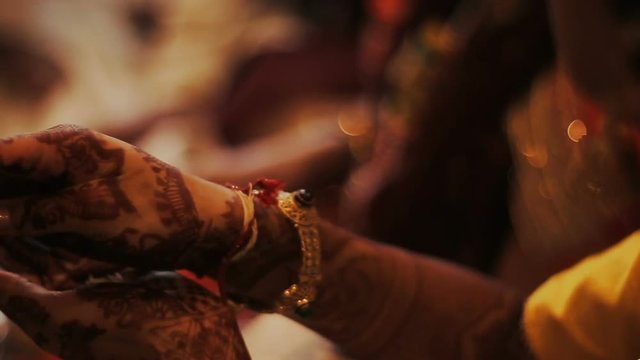 Hindu woman holds her hands with mehendi for pray