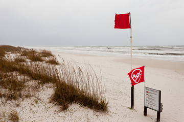 Water closed to public flag on stormy ocean beach